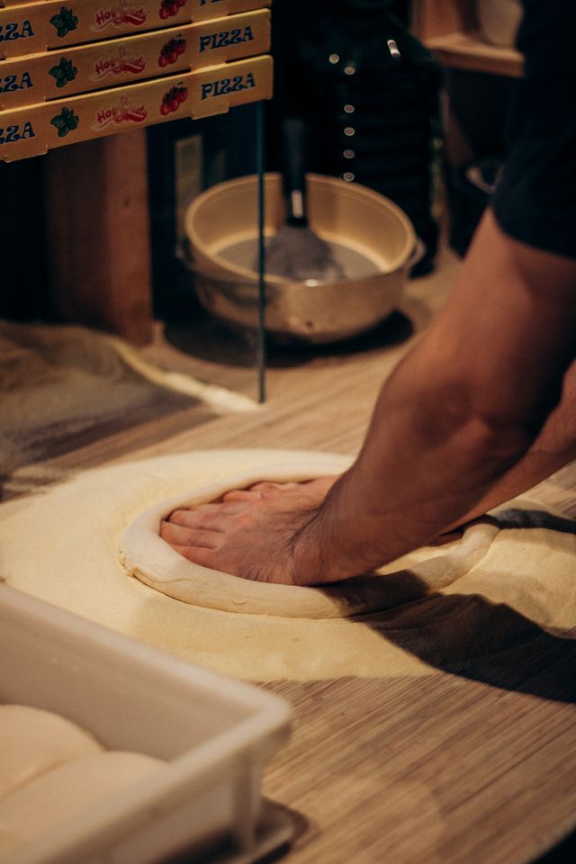 Pizza dough being shaped into a base